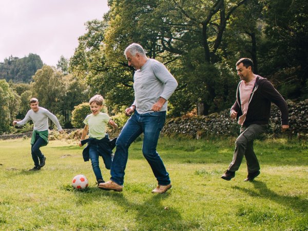 Familia jugando fútbol, disfrutando de su buena salud.